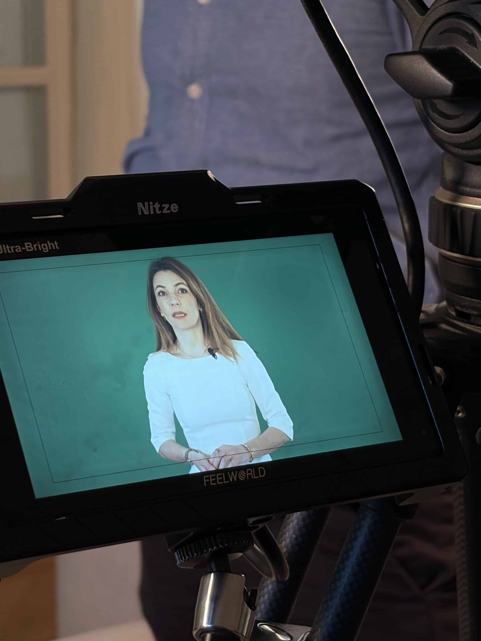 Responsable d'entreprise filmée en interview vidéo professionnelle, visible sur le moniteur de tournage lors d'une captation vidéo