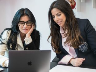 Photo corporate de deux femmes devant un ordinateur