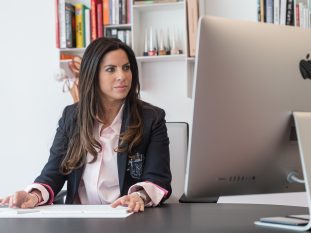 Photo corporate d'une femme assise à son bureau devant un ordinateur